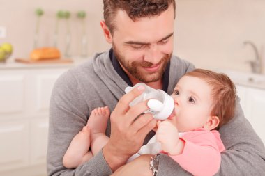 Nice daddy feeding his child 