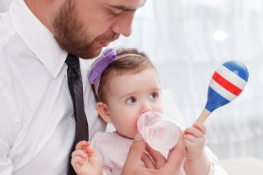 Pleasant father feeding baby