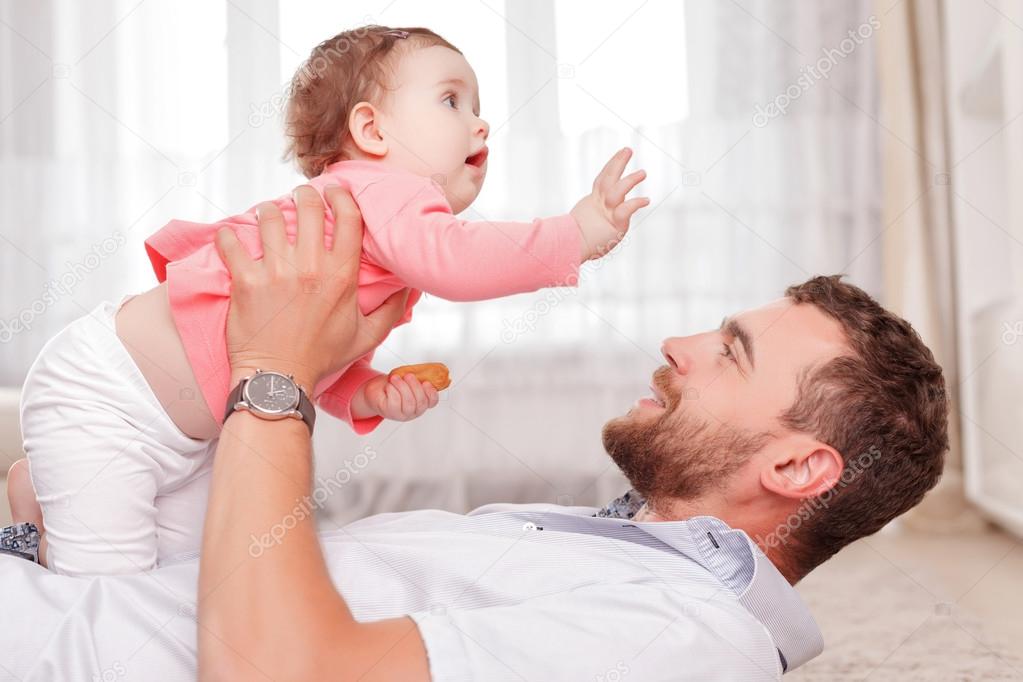 Vivacious father holding his kid in air 