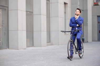 Handsome businessman riding his bicycle 