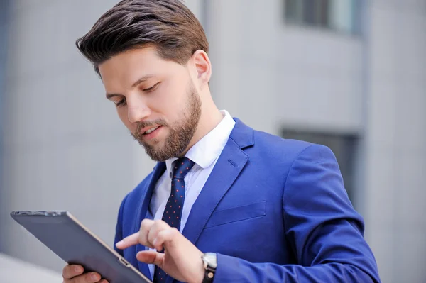 Nice positive bearded businessman holding laptop. — Stockfoto