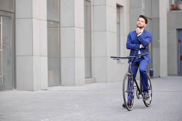 Hombre de negocios guapo montando su bicicleta — Foto de Stock
