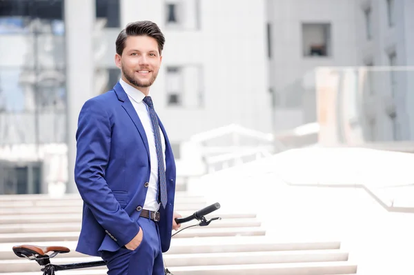 Pleasant businessman standing with bicycle — Stock Fotó