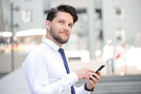 Nice young businessman holding mobile phone — 图库照片