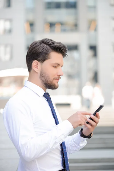 Bonito joven empresario sosteniendo el teléfono móvil —  Fotos de Stock