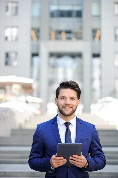 Handsome businessman holding laptop — Stock Photo, Image