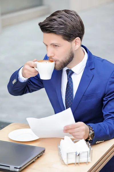 Pleasant young man sitting in cafe — Stockfoto