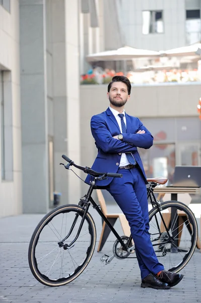 Nice businessman leaning on bicycle — Stok fotoğraf