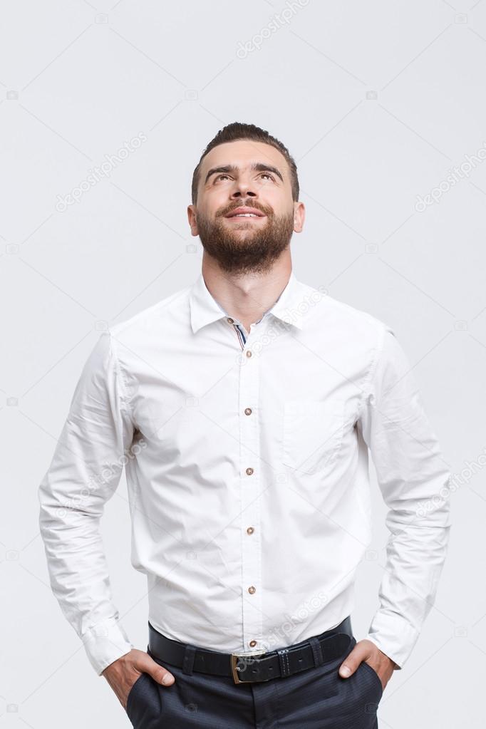Man with beard standing and looking up 