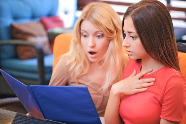 Girls in cafe looking through menu — Stock Photo, Image