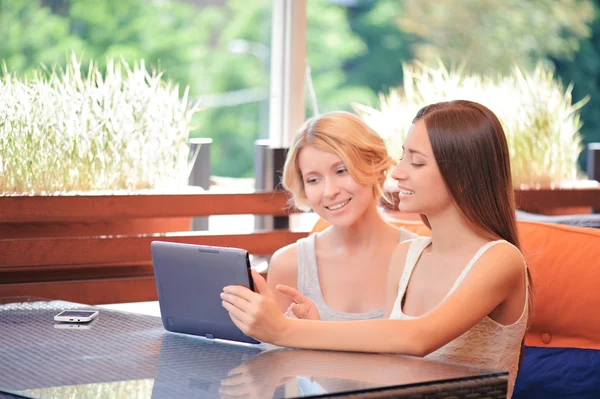 Pair of girlfriends in cafe with tablet — Stock Photo, Image