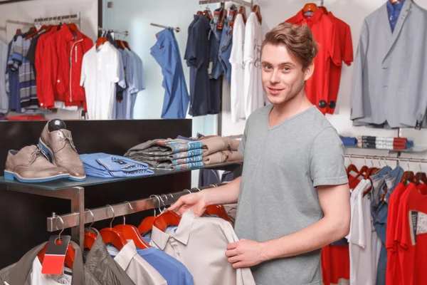 Muž volba tričko pro sebe v butiku — Stock fotografie