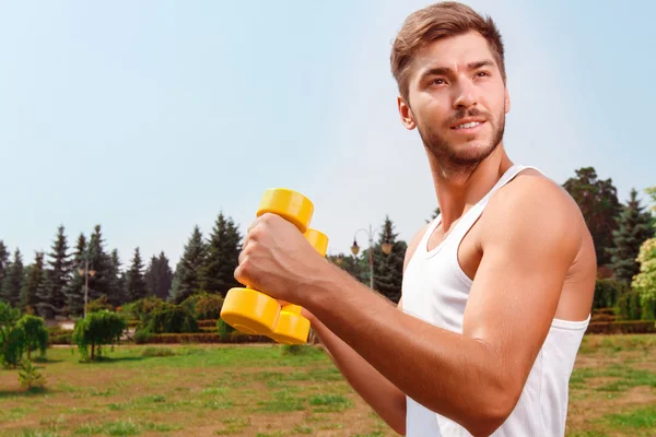 Aangename kerel bedrijf gewichten — Stockfoto