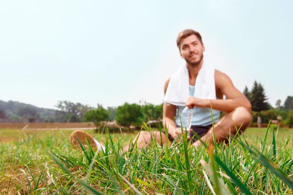 Buen tipo sentado en la hierba — Foto de Stock