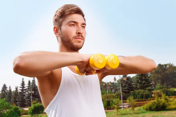 Pleasant guy holding weights — Stock Photo, Image