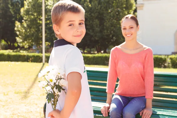 彼の背中の後ろに花を持って少年 — ストック写真