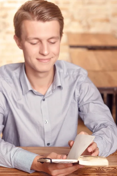 Giovane uomo che legge i suoi appunti nel caffè — Foto Stock