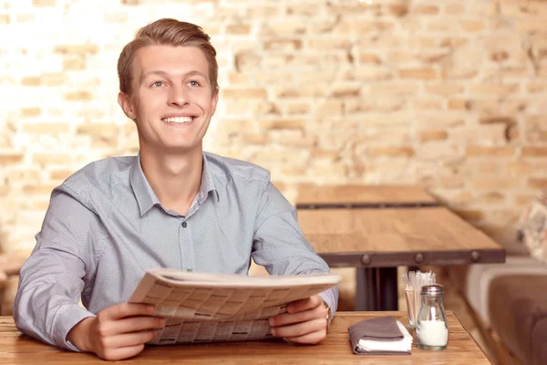 Handsome man with newspaper in cafe — Stock Photo, Image