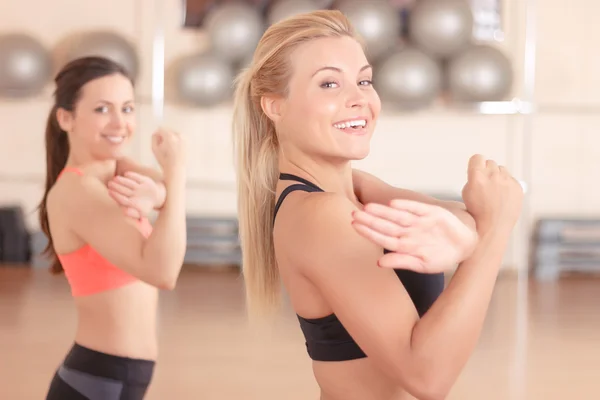 Mujeres bonitas haciendo ejercicios en el gimnasio — Foto de Stock