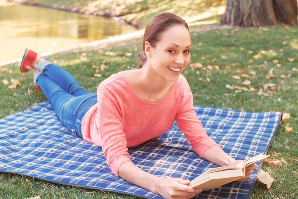 Jeune femme lecture livre dans le parc — Photo