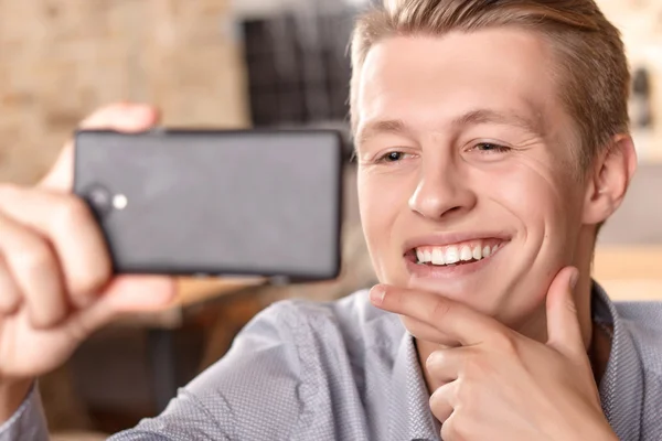 Smiling man doing selfie in cafe — Stock Photo, Image