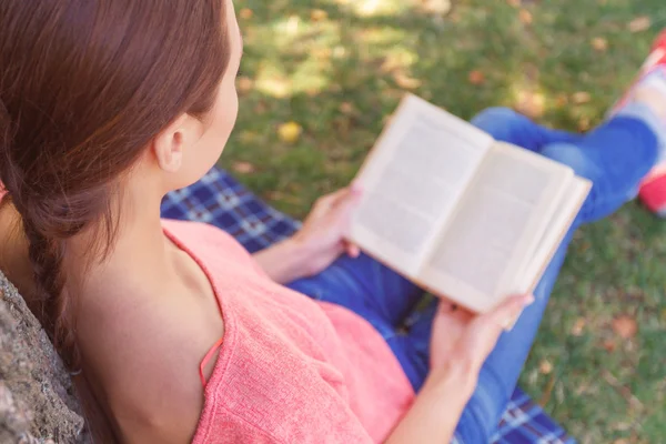 Young woman reading book in park — Stock Photo, Image