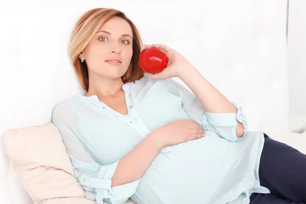 妊娠中の女性は、新鮮なリンゴを押し — ストック写真