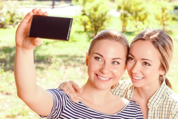 Two girlfriends doing selfie in park — Stock Photo, Image