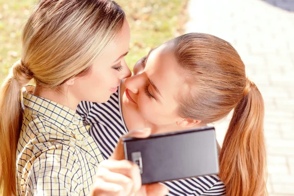 To lesber gjør selfie i parken. – stockfoto