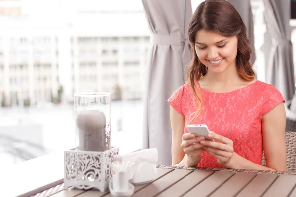 Frau benutzt Handy in Café — Stockfoto