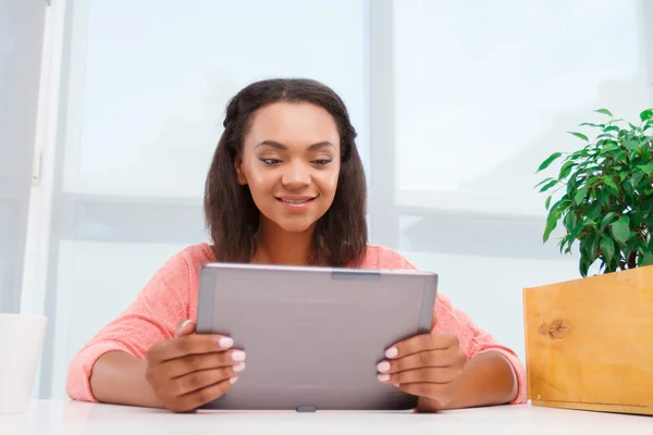 Unga mulatt tjej använder tablet — Stockfoto