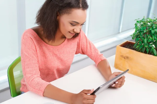 Chica mulata joven usando tableta — Foto de Stock