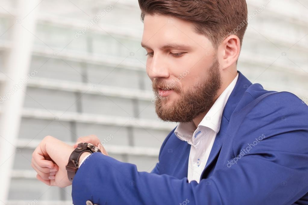Handsome guy with beard checking time