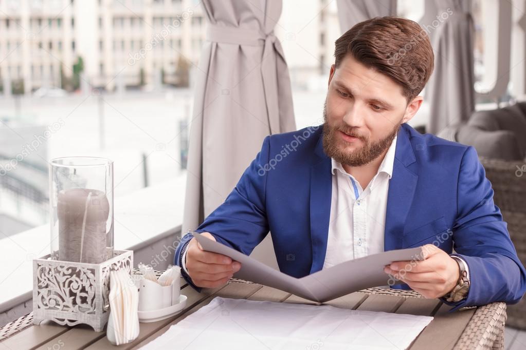 Nice guy reading price list in cafe