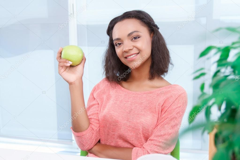 Beautiful mulatto woman holding apple