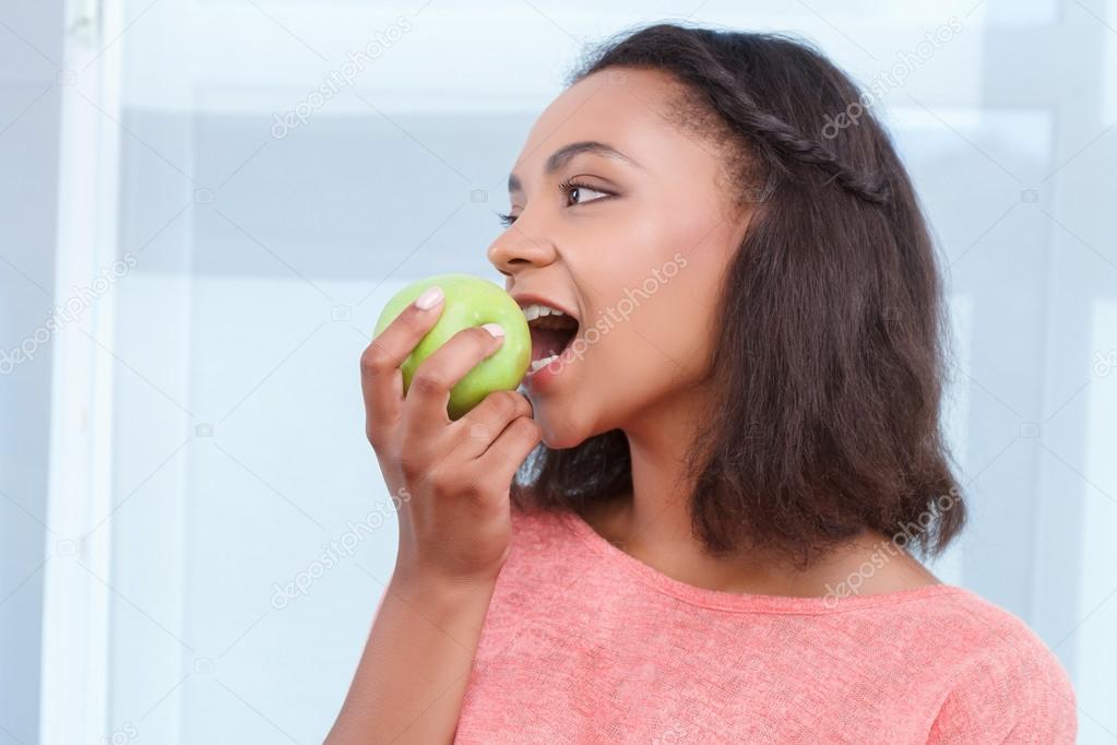 Mulatto lady eating fresh apple