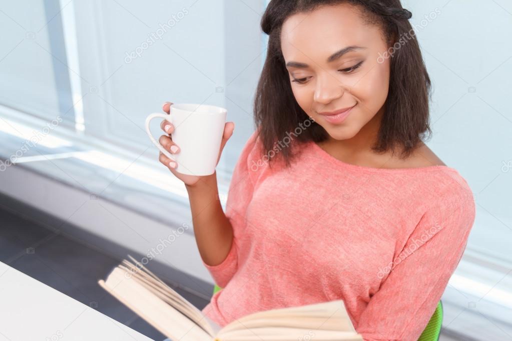 Lady drinking tea and reading book