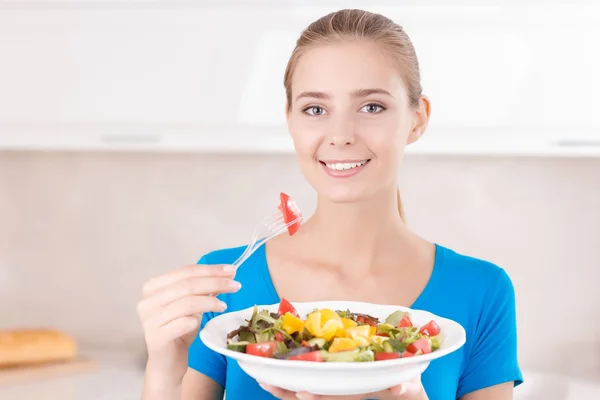 Sorrindo menina comendo salada — Fotografia de Stock