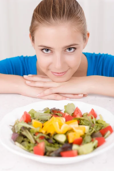 Chica sonriente comiendo ensalada —  Fotos de Stock