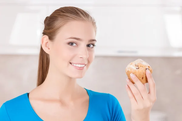 Menina otimista segurando muffin — Fotografia de Stock