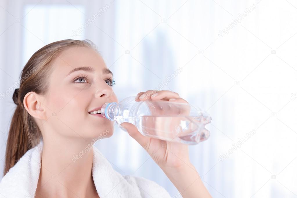 Pleasant girl drinking water 