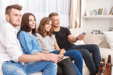 Contented friends watching TV 