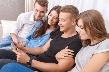Upbeat friends holding laptop 
