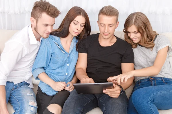 Upbeat friends holding laptop 