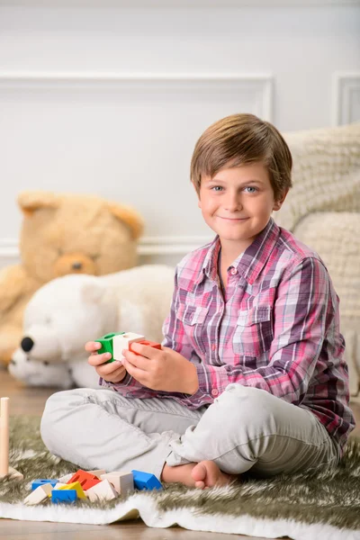Cheerful boy playing on the carpet — Stock Photo, Image