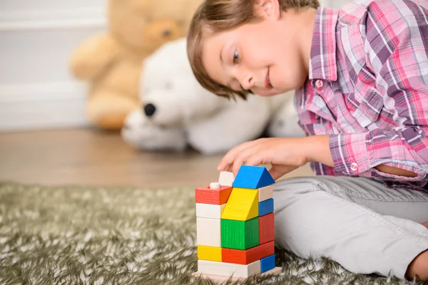 Fröhlicher Junge, der auf dem Teppich spielt — Stockfoto