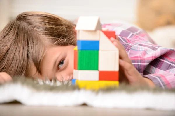 Ragazzo allegro che gioca sul tappeto — Foto Stock