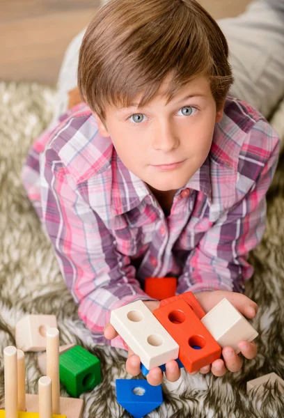 Веселый мальчик играет на ковре — стоковое фото