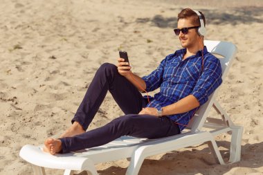 Handsome freelancer lying on the beach