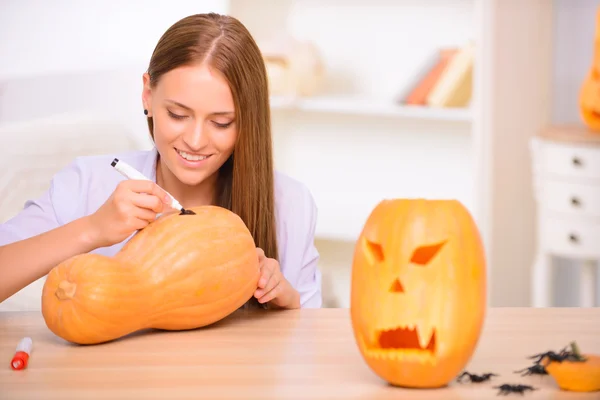 Pretty girl painting on the pumpkin — Stock Photo, Image